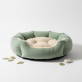 Sage green and beige calming donut cat bed with plush raised edges
